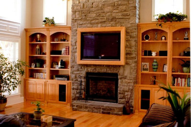 Example of a large classic open concept light wood floor living room design in DC Metro with beige walls, a standard fireplace, a stone fireplace and a media wall