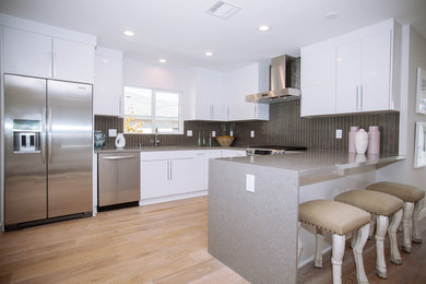 Inspiration for a mid-sized modern u-shaped porcelain tile eat-in kitchen remodel in Los Angeles with a double-bowl sink, flat-panel cabinets, gray cabinets, quartz countertops, white backsplash, stone slab backsplash, stainless steel appliances and no island