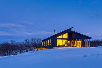 Example of a trendy blue one-story concrete fiberboard house exterior design in Other with a shed roof and a metal roof