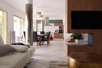 Réalisation d'un salon design avec une cheminée double-face et un téléviseur fixé au mur.