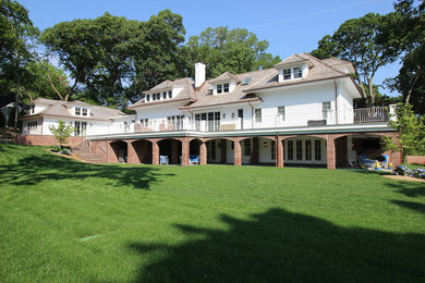 Huge transitional white two-story vinyl exterior home photo in New York with a hip roof