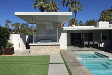 Photo of a large mid-century modern backyard stone landscaping in Los Angeles with a fire pit.