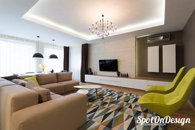 Modelo de salón para visitas abierto contemporáneo extra grande con paredes grises, suelo de madera en tonos medios, televisor colgado en la pared y suelo marrón