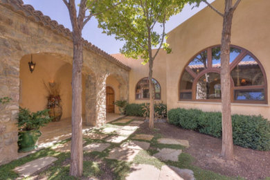Inspiration for a mid-sized southwestern beige one-story mixed siding flat roof remodel in Albuquerque