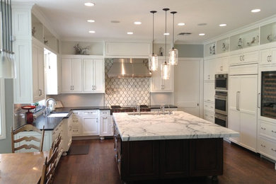 Large trendy u-shaped dark wood floor and brown floor eat-in kitchen photo in Las Vegas with an undermount sink, shaker cabinets, white cabinets, marble countertops, gray backsplash, marble backsplash, stainless steel appliances and an island