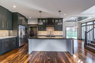 Inspiration for a large galley medium tone wood floor and multicolored floor eat-in kitchen remodel in Kansas City with an undermount sink, black cabinets, quartz countertops, multicolored backsplash, mosaic tile backsplash, stainless steel appliances, an island and white countertops