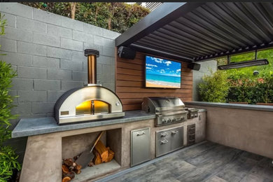 Inspiration for a contemporary backyard patio kitchen remodel in Orange County with a pergola