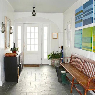 Idées déco pour une entrée éclectique de taille moyenne avec un vestiaire, un mur blanc, un sol en ardoise, une porte simple et une porte blanche.