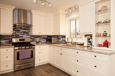 Example of a classic l-shaped medium tone wood floor and brown floor eat-in kitchen design in Toronto with shaker cabinets, white cabinets, quartzite countertops, stainless steel appliances, a double-bowl sink, multicolored backsplash, matchstick tile backsplash and a peninsula