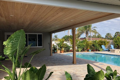 Example of a backyard patio design in Orlando with a roof extension
