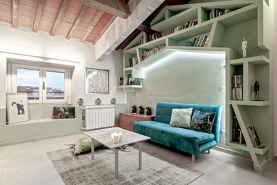 フィレンツェにある中くらいなモダンスタイルのおしゃれなリビングロフト (ライブラリー、緑の壁、磁器タイルの床、壁掛け型テレビ、ベージュの床、表し梁、レンガ壁) の写真