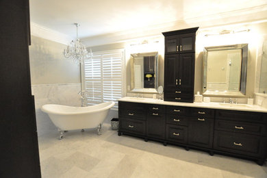 Inspiration for a large traditional master bathroom in Atlanta with raised-panel cabinets, black cabinets, stone tile, marble benchtops, a freestanding tub, an alcove shower, a one-piece toilet, grey walls, marble floors and an undermount sink.