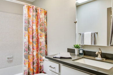 Example of a mid-sized transitional master gray tile porcelain tile, beige floor and single-sink bathroom design in Phoenix with shaker cabinets, white cabinets, a two-piece toilet, gray walls, an undermount sink, quartz countertops, gray countertops and a built-in vanity