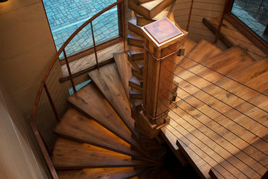 Example of a large urban wooden curved open staircase design in Other
