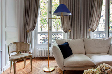 Cette photo montre un grand salon tendance ouvert avec un mur blanc, un sol en bois brun, aucun téléviseur et boiseries.