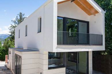 Modelo de fachada de casa blanca y negra moderna de tamaño medio de dos plantas con revestimiento de piedra y tejado a dos aguas