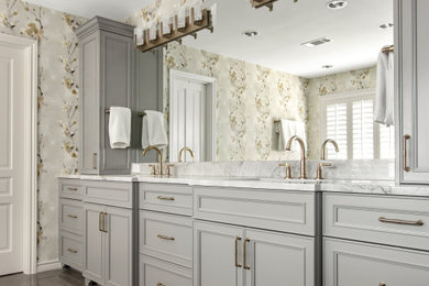 This is an example of a transitional master bathroom in Dallas with recessed-panel cabinets, grey cabinets, an undermount tub, a two-piece toilet, blue tile, ceramic tile, multi-coloured walls, marble floors, quartzite benchtops, grey floor, white benchtops, a shower seat, a double vanity, a built-in vanity and wallpaper.