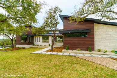 Inspiration for a mid-sized modern two-story mixed siding house exterior remodel in Austin with a shed roof and a metal roof