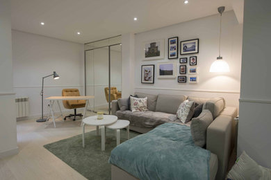 Inspiration for a small modern mezzanine living room in Madrid with white walls, light hardwood flooring, a wall mounted tv and beige floors.