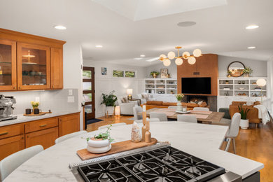 Example of a 1960s medium tone wood floor open concept kitchen design in Seattle with an undermount sink, flat-panel cabinets, medium tone wood cabinets, quartzite countertops, gray backsplash, ceramic backsplash, stainless steel appliances, an island and yellow countertops