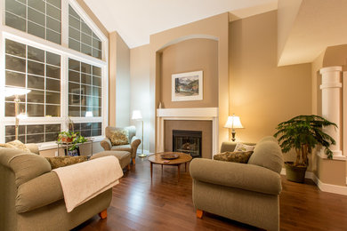 Mid-sized elegant formal and open concept medium tone wood floor living room photo in Edmonton with beige walls, a standard fireplace, a tile fireplace and no tv