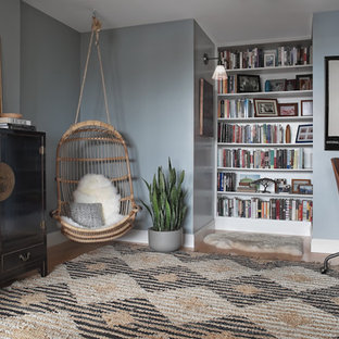 Bild på ett mellanstort orientaliskt hemmabibliotek, med blå väggar, mellanmörkt trägolv, ett inbyggt skrivbord och brunt golv
