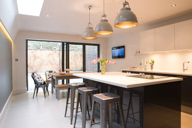 Mid-sized contemporary single-wall eat-in kitchen in Kent with flat-panel cabinets, white splashback, with island and white floor.