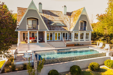 Inspiration for a large contemporary gray two-story wood exterior home remodel in New York with a shingle roof