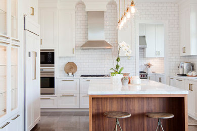 Inspiration for a large transitional u-shaped eat-in kitchen in Vancouver with an undermount sink, shaker cabinets, white cabinets, marble benchtops, white splashback, subway tile splashback, panelled appliances, concrete floors, with island and grey floor.