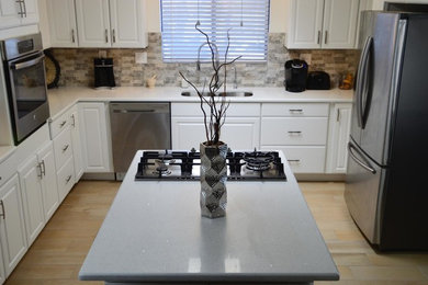 Mid-sized transitional l-shaped porcelain tile enclosed kitchen photo in Austin with raised-panel cabinets, beige backsplash, porcelain backsplash, stainless steel appliances, no island, white cabinets and quartz countertops