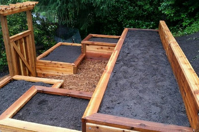 This is an example of a mid-sized craftsman full sun hillside mulch vegetable garden landscape in Other for summer.
