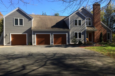 Example of a large trendy attached three-car garage design in New York