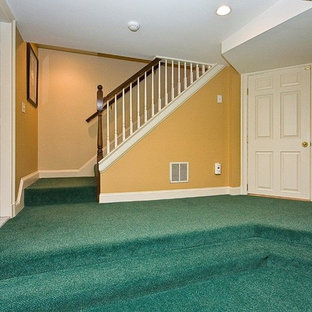 Design ideas for an expansive traditional walk-out basement in Boston with yellow walls, carpet and turquoise floors.