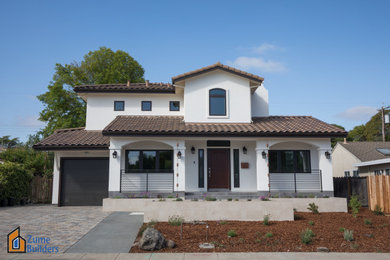 Foto de fachada de casa blanca y marrón de estilo americano grande de dos plantas con revestimiento de estuco, tejado a dos aguas y tejado de teja de barro