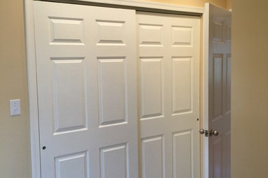 Foto de armario unisex tradicional de tamaño medio con suelo de baldosas de cerámica, armarios con paneles con relieve, puertas de armario blancas y suelo beige