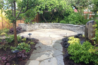 Mid-sized arts and crafts backyard garden in Seattle with natural stone pavers.