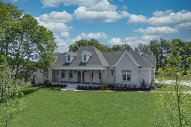 Imagen de fachada de casa blanca y gris de estilo americano grande de dos plantas con revestimiento de ladrillo, tejado a cuatro aguas, tejado de teja de madera y panel y listón