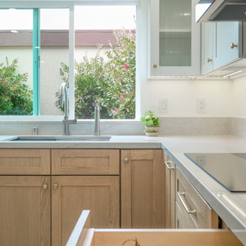 Modern White and Natural Oak Kitchen with Brass Hardware and Quartz Backsplash