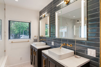 Mid-sized minimalist master blue tile and porcelain tile porcelain tile, gray floor and double-sink wet room photo in Miami with recessed-panel cabinets, black cabinets, an undermount tub, a two-piece toilet, white walls, a vessel sink, quartz countertops, a hinged shower door, white countertops, a niche and a freestanding vanity