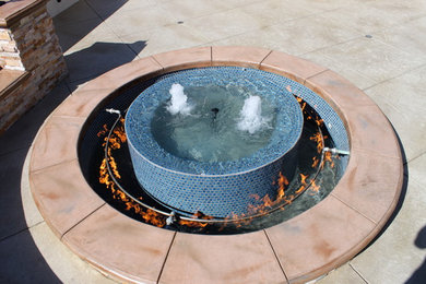 Trendy backyard stamped concrete patio photo in Los Angeles with a fire pit