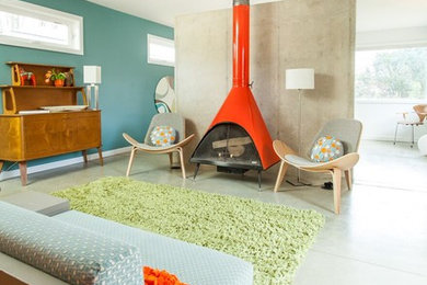 Inspiration for a mid-sized modern open concept concrete floor living room remodel with blue walls, a standard fireplace, a metal fireplace and no tv