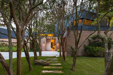 Large contemporary red two-story brick flat roof idea in Houston