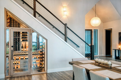 Small minimalist medium tone wood floor and brown floor wine cellar photo in Portland with display racks