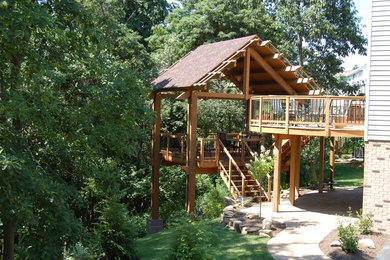 Inspiration for a huge craftsman backyard deck remodel in Other with a pergola