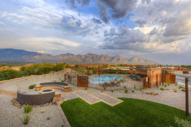 Design ideas for a mid-sized southwestern drought-tolerant, desert and full sun concrete paver and metal fence landscaping in Phoenix for summer.