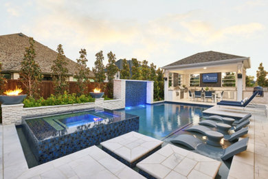 Diseño de piscina moderna de tamaño medio a medida en patio trasero con adoquines de piedra natural