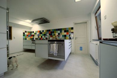 Küche freihägend mit Glasfront und Edelstahlarbeitsplatte