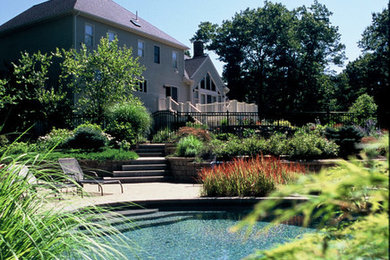 Pool landscaping - large traditional backyard concrete paver and custom-shaped natural pool landscaping idea in Other