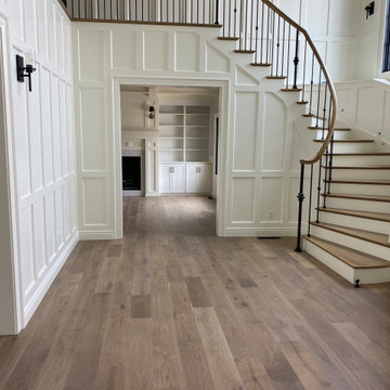Entry with painted and stained stairway, white painted wainscoting, looking into