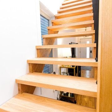 Open-Riser Oak Staircase with Black Spindles and Wood Handrail | East York